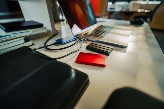 Laptop i zewnętrzne dyski SSD na uporządkowanym biurku Laptop i zewnętrzne dyski SSD na uporządkowanym biurku