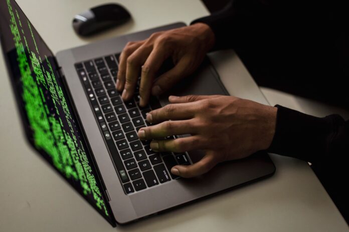 Mężczyzna piszący na netbooku z danymi na ekranie przy biurku Mężczyzna piszący na netbooku z danymi na ekranie przy biurku