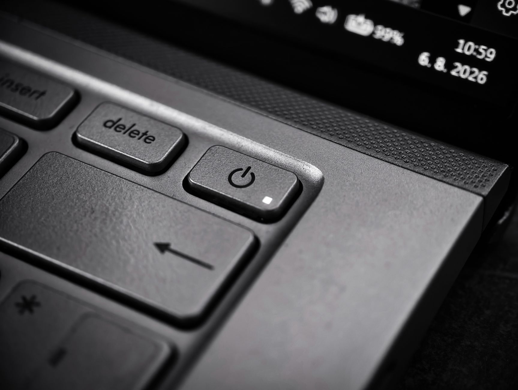 Zbliżenie na przycisk zasilania na klawiaturze laptopa w czerni i bieli